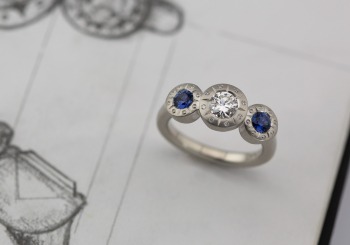 Yogo Sapphire accents and Geometric elements elevate with classic Engagement ring.